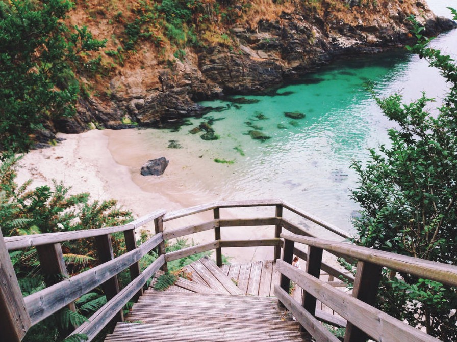 Cala Sonreiras con area dourada e cantís verdes